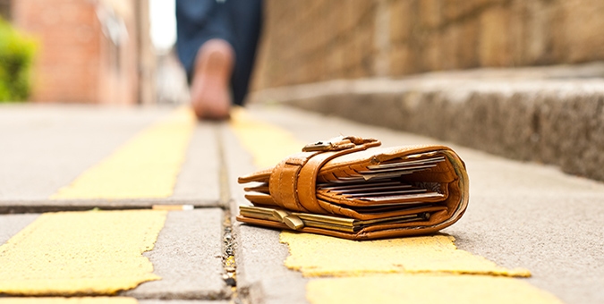 a brown leather wallet left on a sidewalk