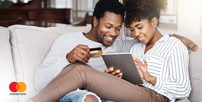 a couple smiling while sitting on a couch