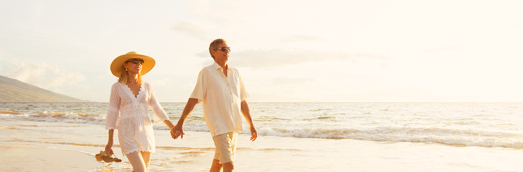 a couple holding hands walking on a beach