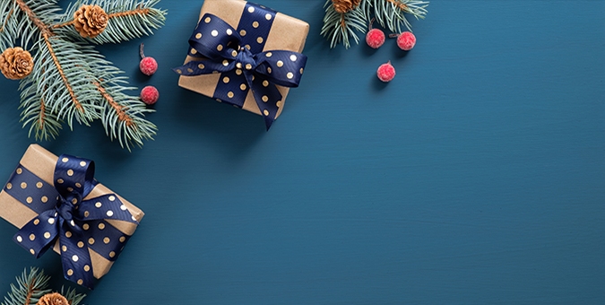 blue background with holiday gifts and greenery