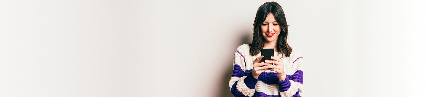 a woman standing viewing her mobile phone