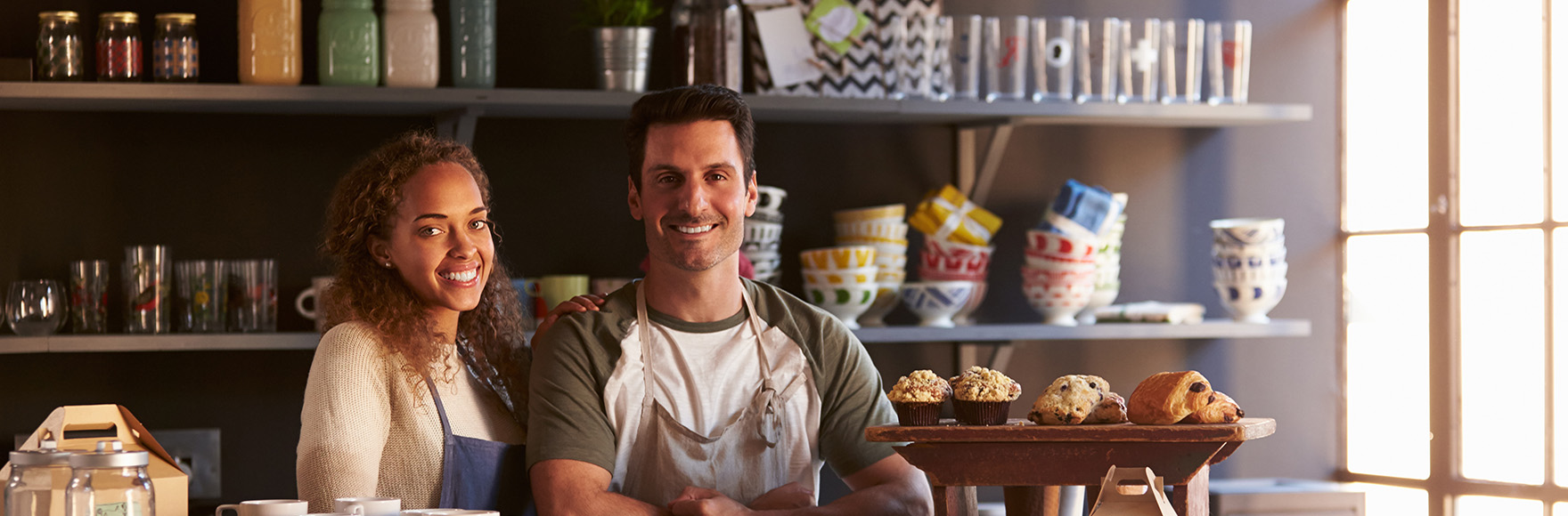 a man and a woman smiling in their small business venue